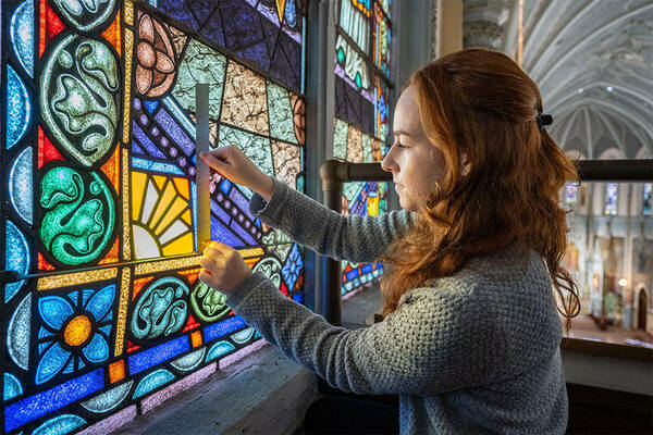 Student measuring stained glass for Painting with Light course taught by Prof. Stephen Hartley